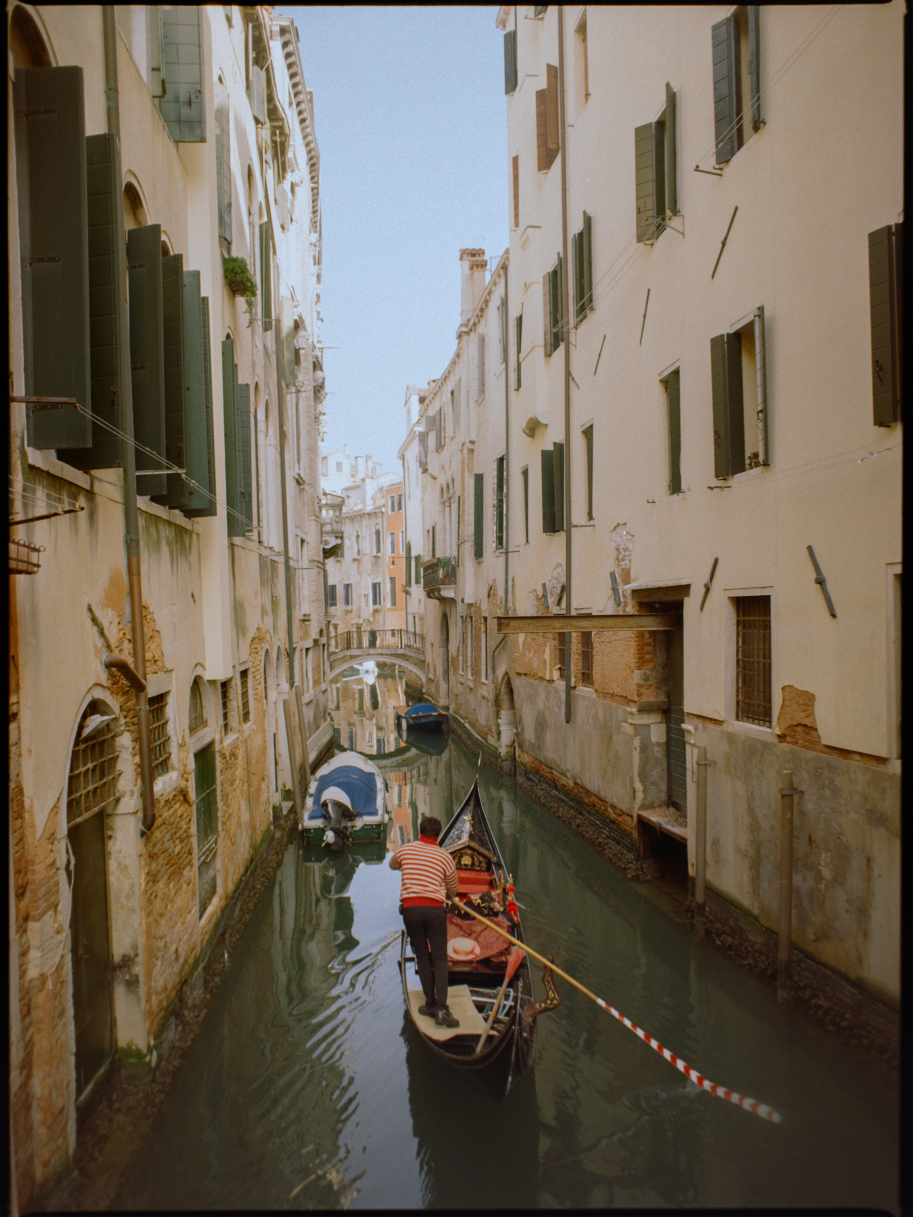 Gondolier rowing through a narrow canal seen from above — Venice on medium format film