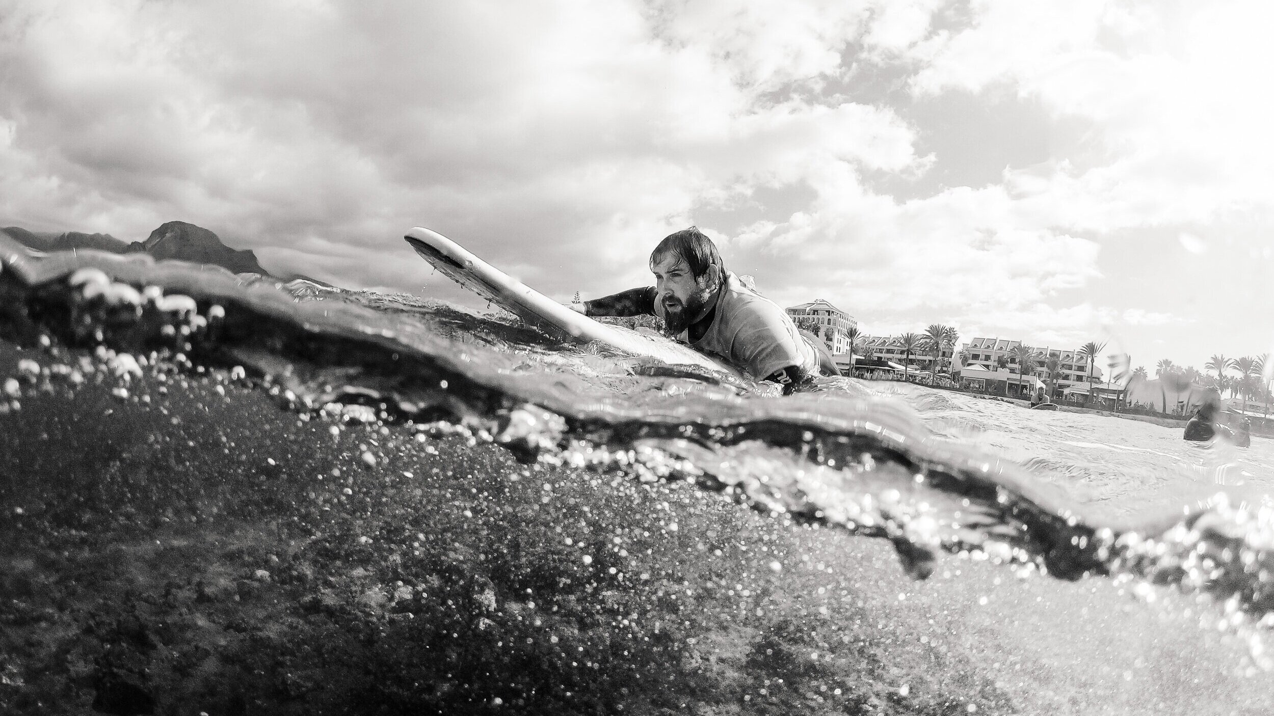black white surfer paddling ocean wave lifestyle photographer london