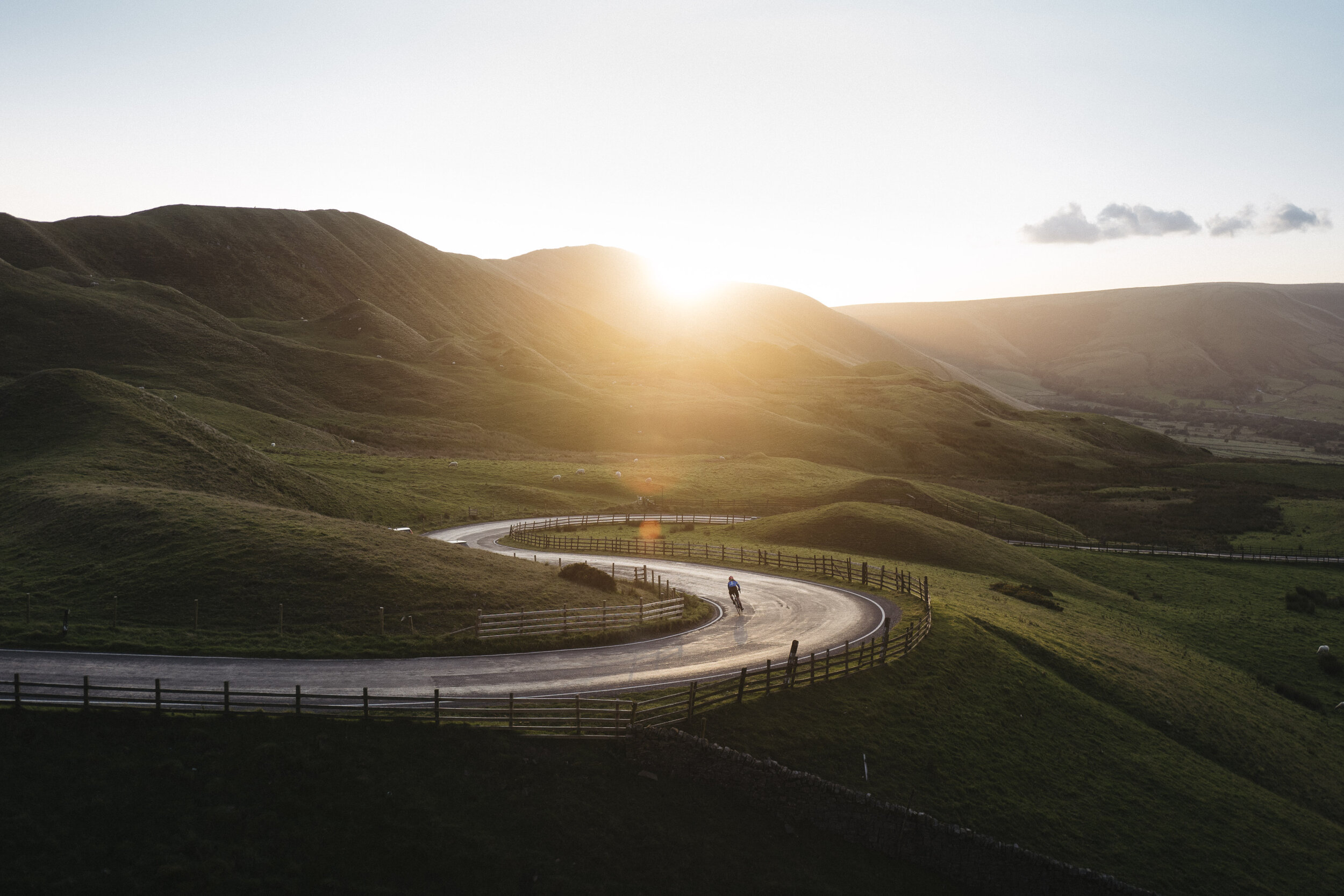 cyclist winding road golden hour hills commercial lifestyle photographer london